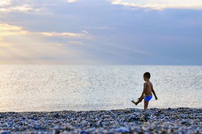 Boy on beach against sky