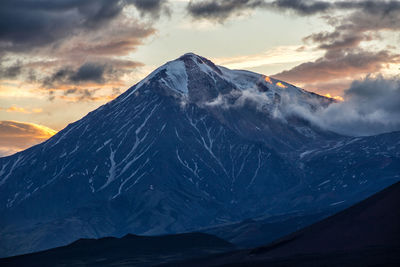 Scenic view of snowcapped mountains against sky during sunset