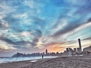 Scenic view of beach against cloudy sky