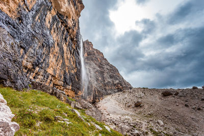 Low angle view of rocky mountain against sky