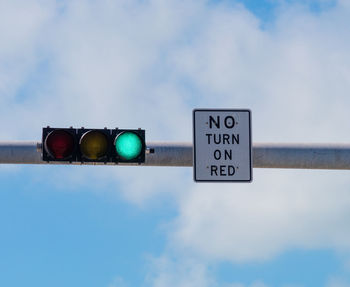 Low angle view of road sign against sky