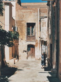 People walking on alley amidst buildings in city