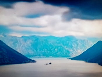 Scenic view of sea and mountains against blue sky