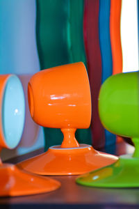 Close-up of multi colored cups with their plate on table