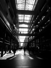 Rear view of people walking in tunnel