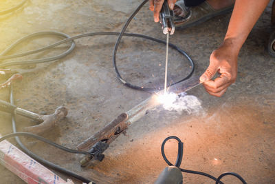 Low section of man welding metal
