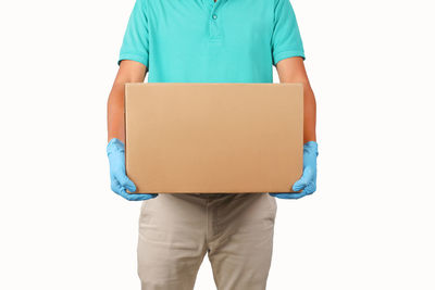 Midsection of man holding umbrella against white background