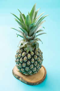 A pineapple photographed on a light blue background.