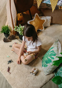 High angle view of girl sitting on bed at home