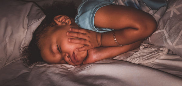 High angle view of baby sleeping on bed