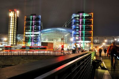 Illuminated berlin hauptbahnhof in city against sky at night