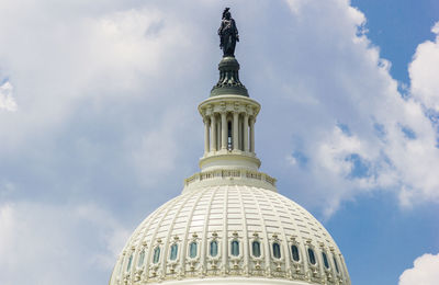 Low angle view of statue on dome against sky