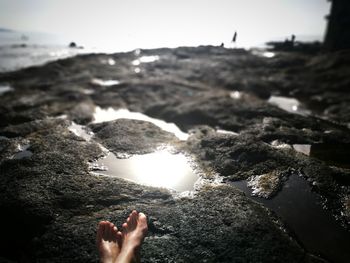 Midsection of person on rock at beach