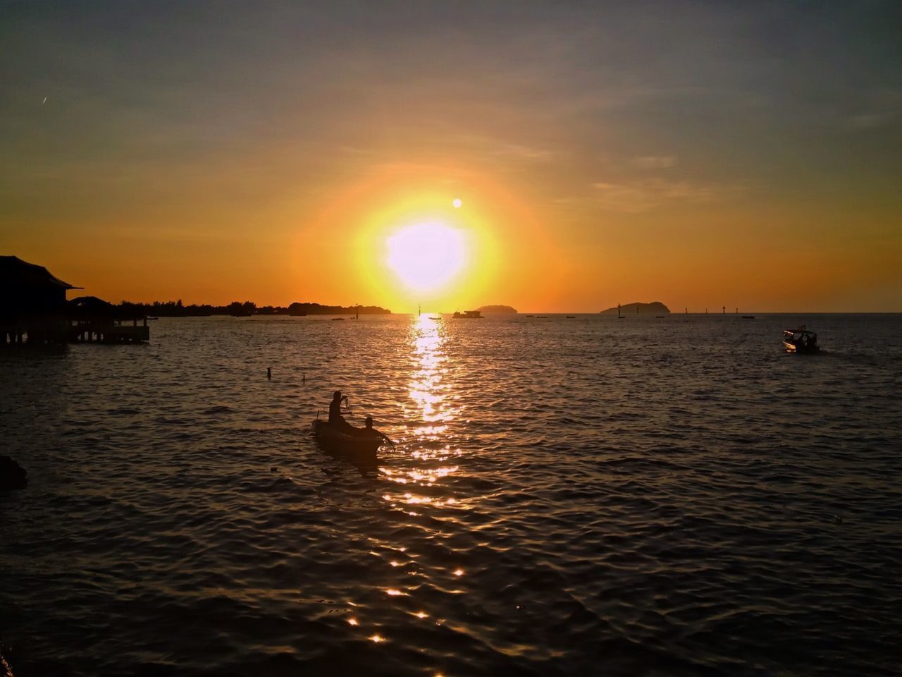 sunset, water, sun, sea, orange color, scenics, beauty in nature, tranquil scene, nautical vessel, reflection, tranquility, rippled, sky, waterfront, silhouette, boat, transportation, horizon over water, idyllic, sunlight