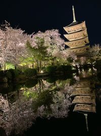 View of temple by lake against sky at night