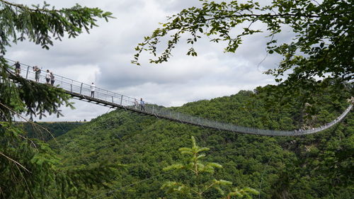 Scenic view of landscape wirh suspension bridge against sky