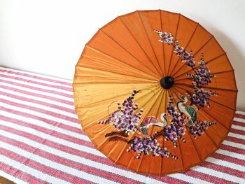 Close-up of designs on orange umbrella at home