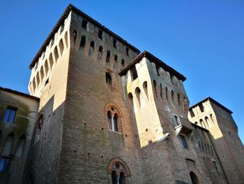 Low angle view of historical building against clear blue sky