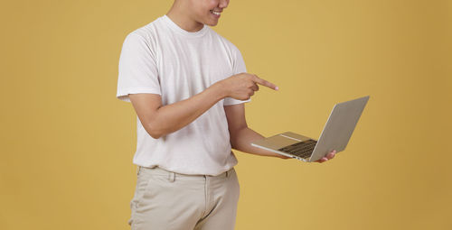 Midsection of man using mobile phone