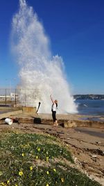 Full length of young woman in sea against sky