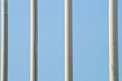 Clear blue sky seen through fence