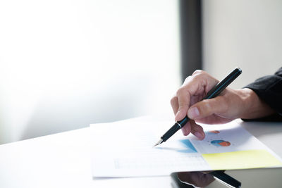 Midsection of woman holding umbrella on paper