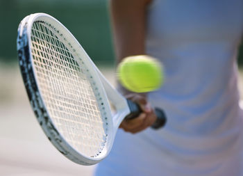 Midsection of man playing tennis