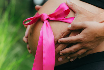 Cropped hands of man touching woman stomach