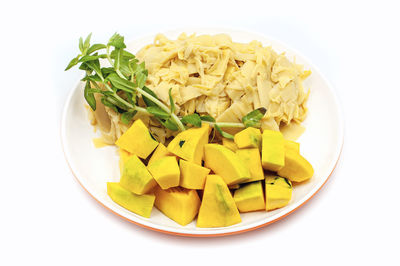 High angle view of chopped vegetables in plate against white background