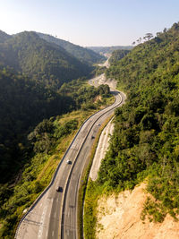 High angle view of road amidst trees against sky