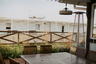 Empty chairs and tables in swimming pool against building