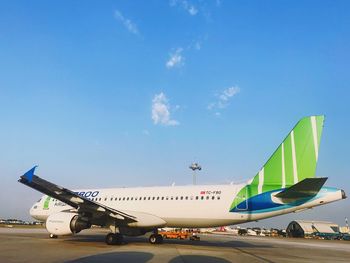 Airplane on airport runway against sky