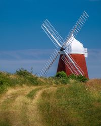 Traditional windmill on field against sky