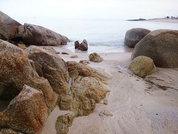 Rocks on beach against sky