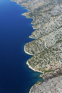 High angle view of sea shore against blue sky