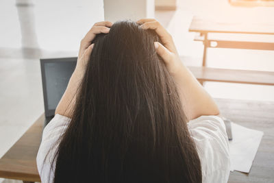 Rear view of woman relaxing at home