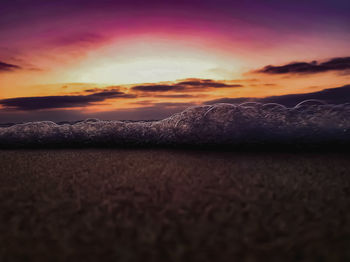 Surface level of sea against sky during sunset