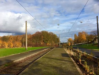 Railroad tracks by plants against sky