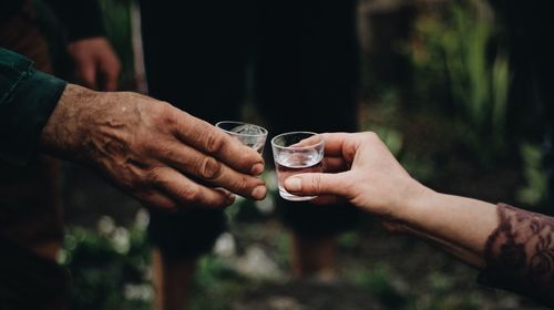 Midsection of man holding a glass of vodka 