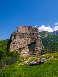 Built structure on field against clear blue sky