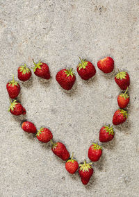 Directly above shot of strawberry heart shape over white background