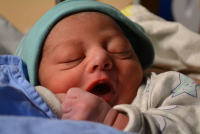 Close-up of cute baby boy lying on bed at home, new born 