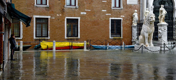 Wet street against buildings at piazza san marco during rainy season