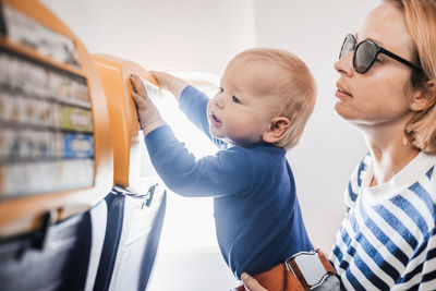 Mom and child flying by plane. mother holding and playing with her infant baby boy child in her lap