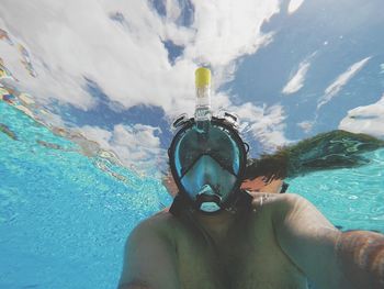 Shirtless man swimming undersea