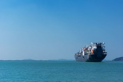 Ship in sea against clear blue sky