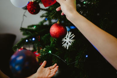 Cropped hands touching christmas tree