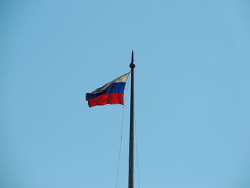 Low angle view of flag flags against clear blue sky