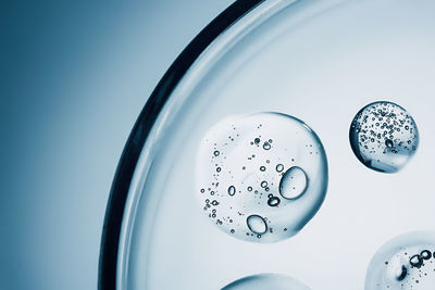 Collagen gel with bubble texture, close-up of transparent smear on blue background