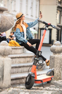 Woman sitting on motorcycle in city